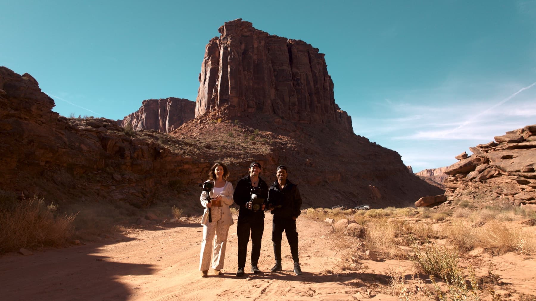 The MediaGeekz crew standing together beneath the red rock cliffs of Moab
